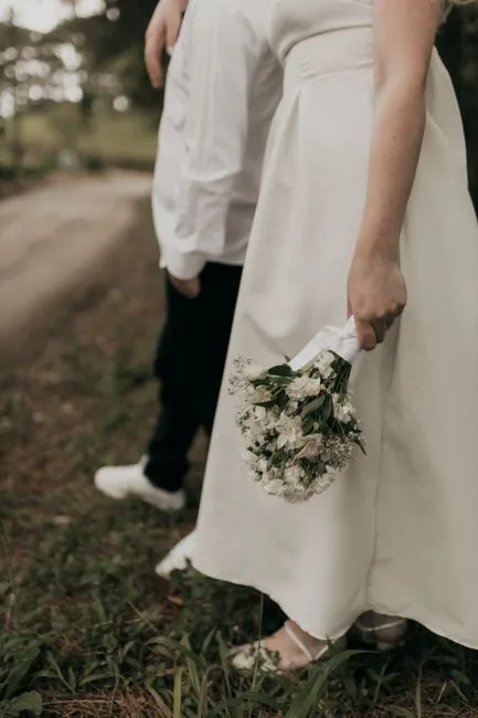 A bouquet held in the hand with long trailing ribbon