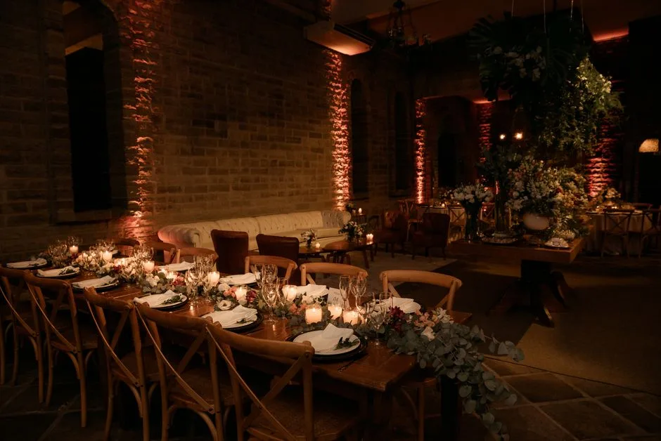 A long dinner table with low floral arrangements and candles